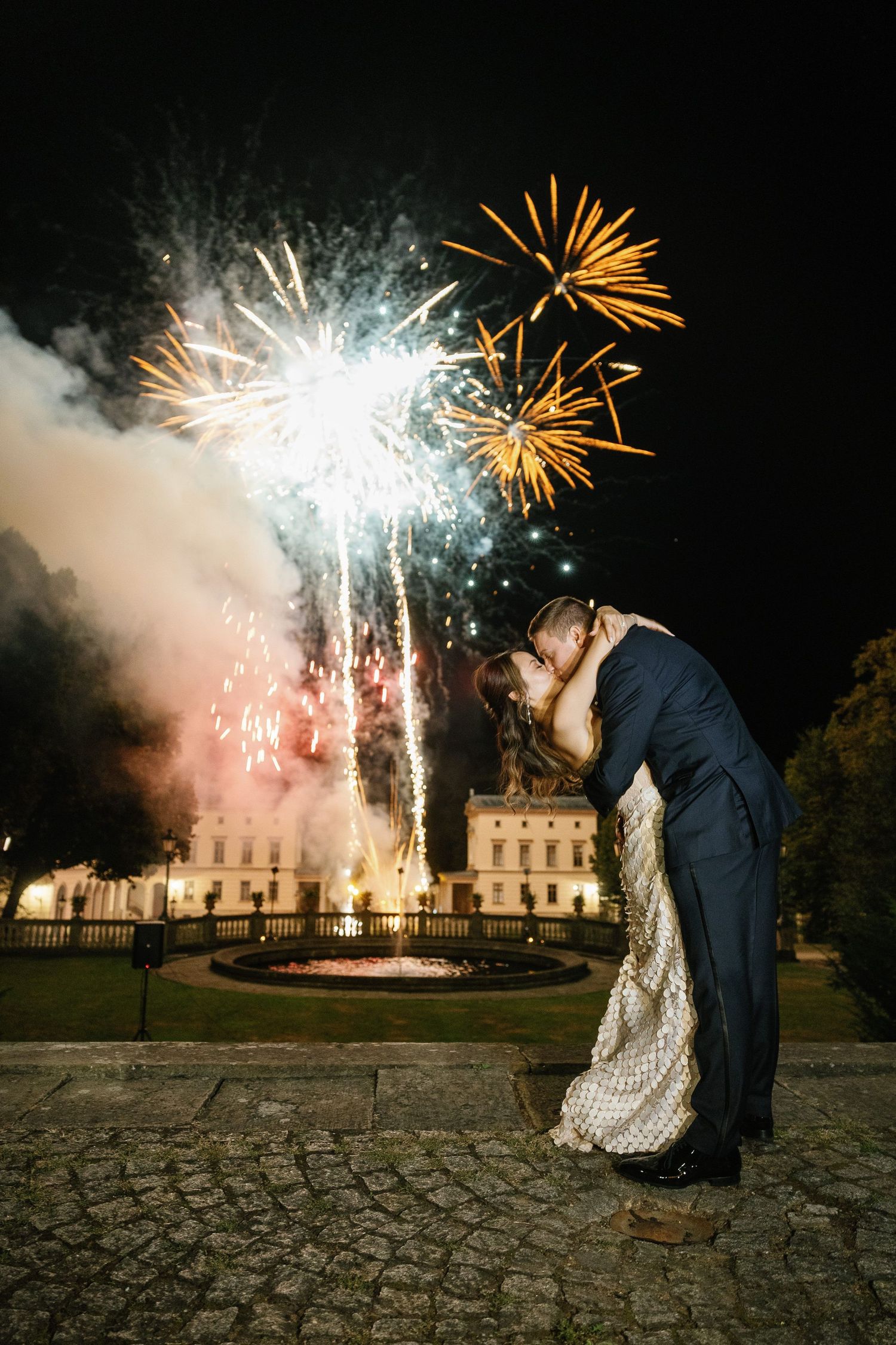 A romantic dip kiss under spectacular fireworks display at an elegant estate. Organized wedding by MyCastleWedding in Dresden/Germany