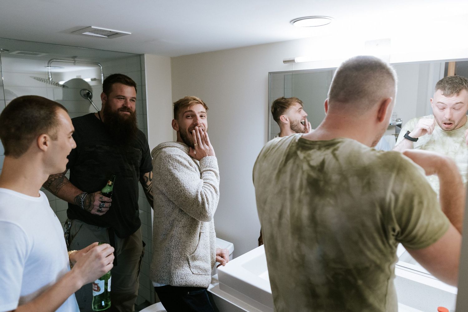 Group of people laughing and getting ready in casual attire in a bright indoor setting.
