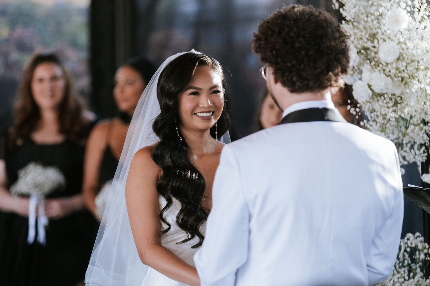A beautiful wedding ceremony with white floral decorations in an elegant indoor venue.
