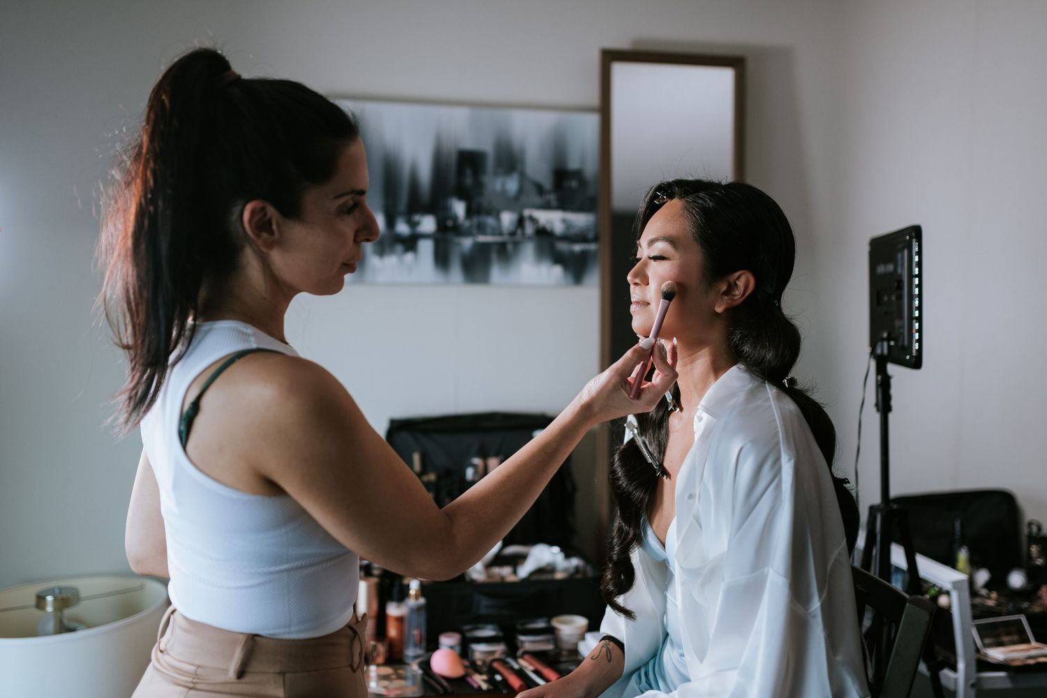 Behind the scenes makeup preparation in a modern room with natural light.