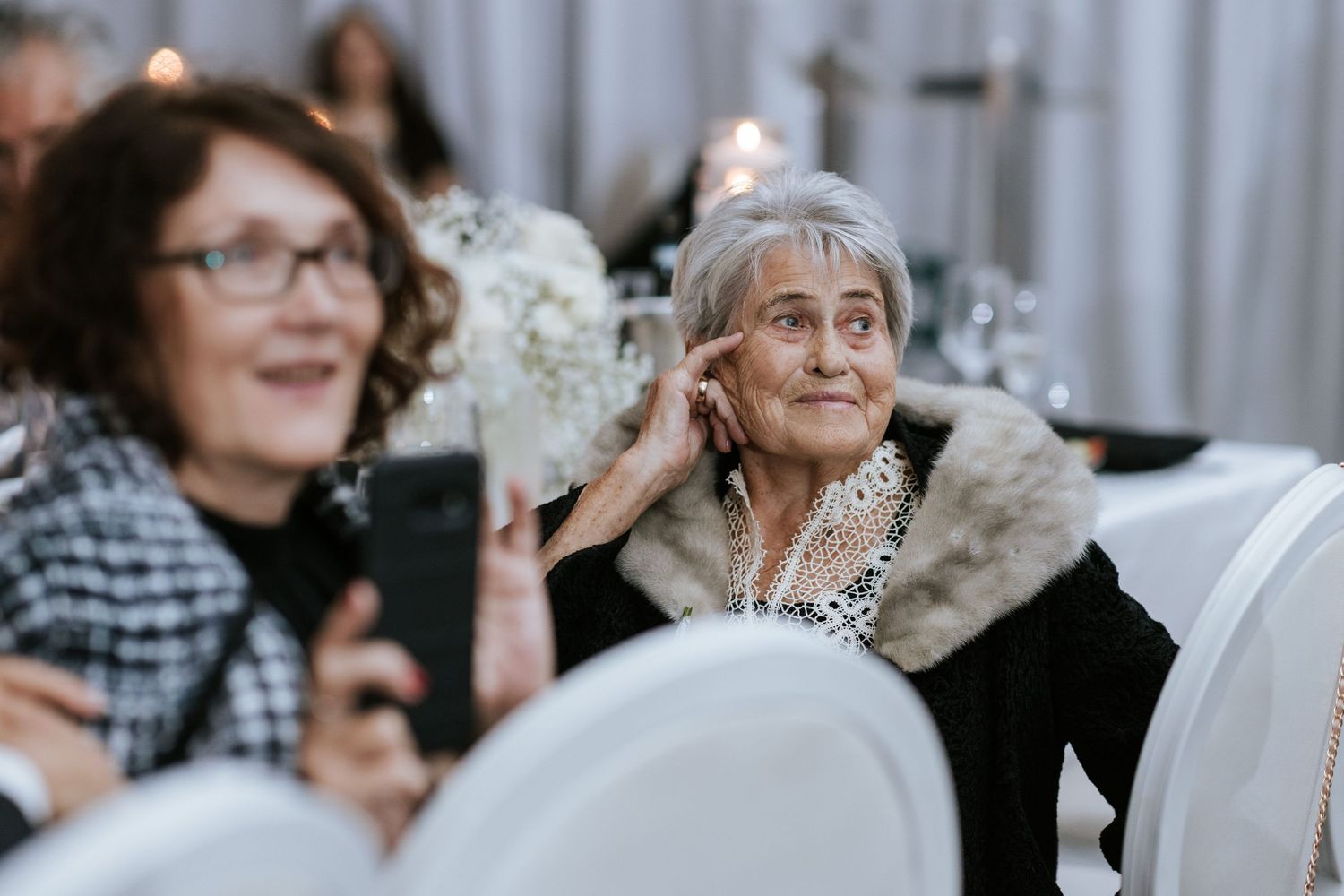 Wedding guests watching and taking photos during reception celebration.