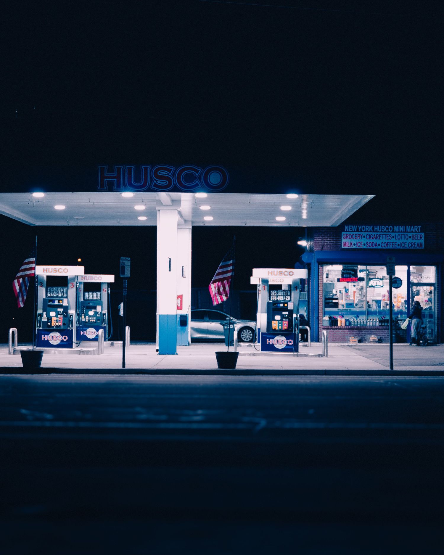 Illuminated Husky gas station at night with blue and white lighting.