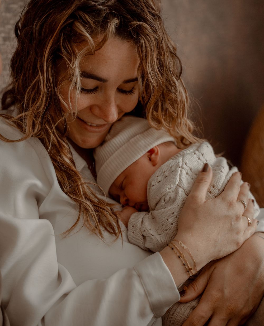 Series of intimate moments showing a baby being cradled and loved in soft, warm lighting.