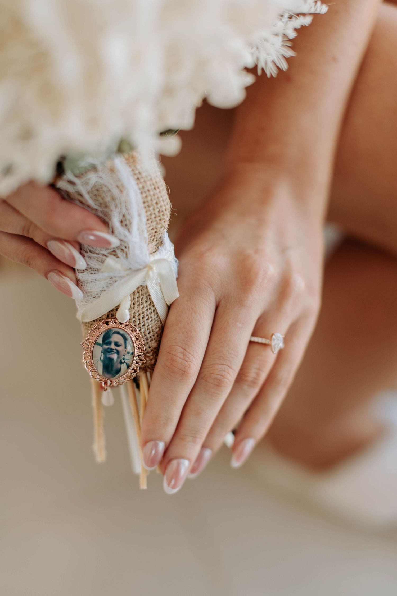 Close-up of manicured hands with engagement ring and decorative lace details.