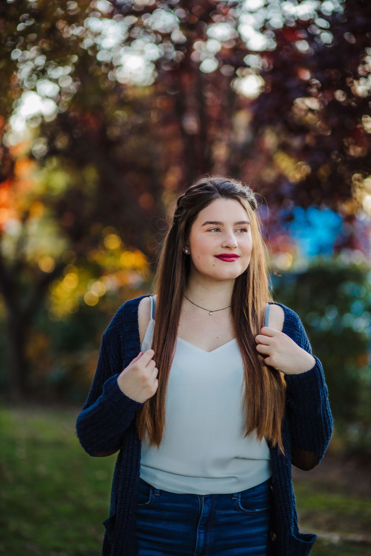 Portrait outdoors with autumn bokeh and colorful blurred forest background.