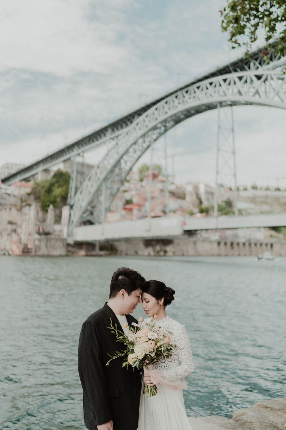 Destination wedding couple overlooking the Douro River and the city of Porto, captured during golden hour with cinematic light.