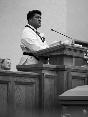 The husband stands and speaks at the pulpit of the church