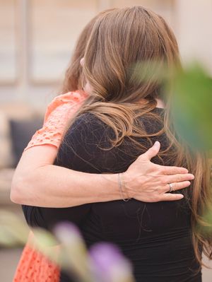 A friend hugs the woman who lost her mother