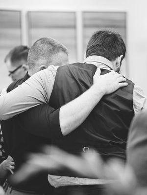 two men put an arm around each other's shoulders