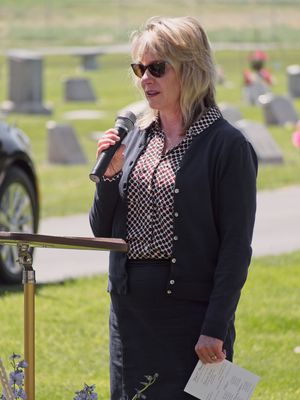 A woman shares her thoughts at a graveside service