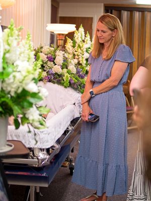A woman has a quiet moment at the viewing of her cousin