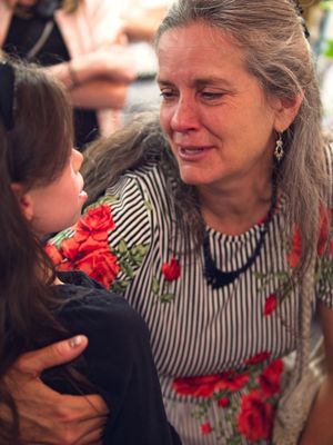 A tearful woman shares a moment with a young girl
