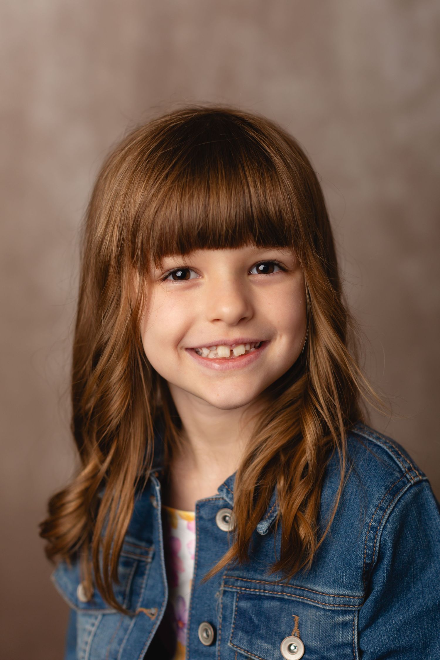 Homeschool child in casual outfit, smiling for a simple school portrait on a beige background