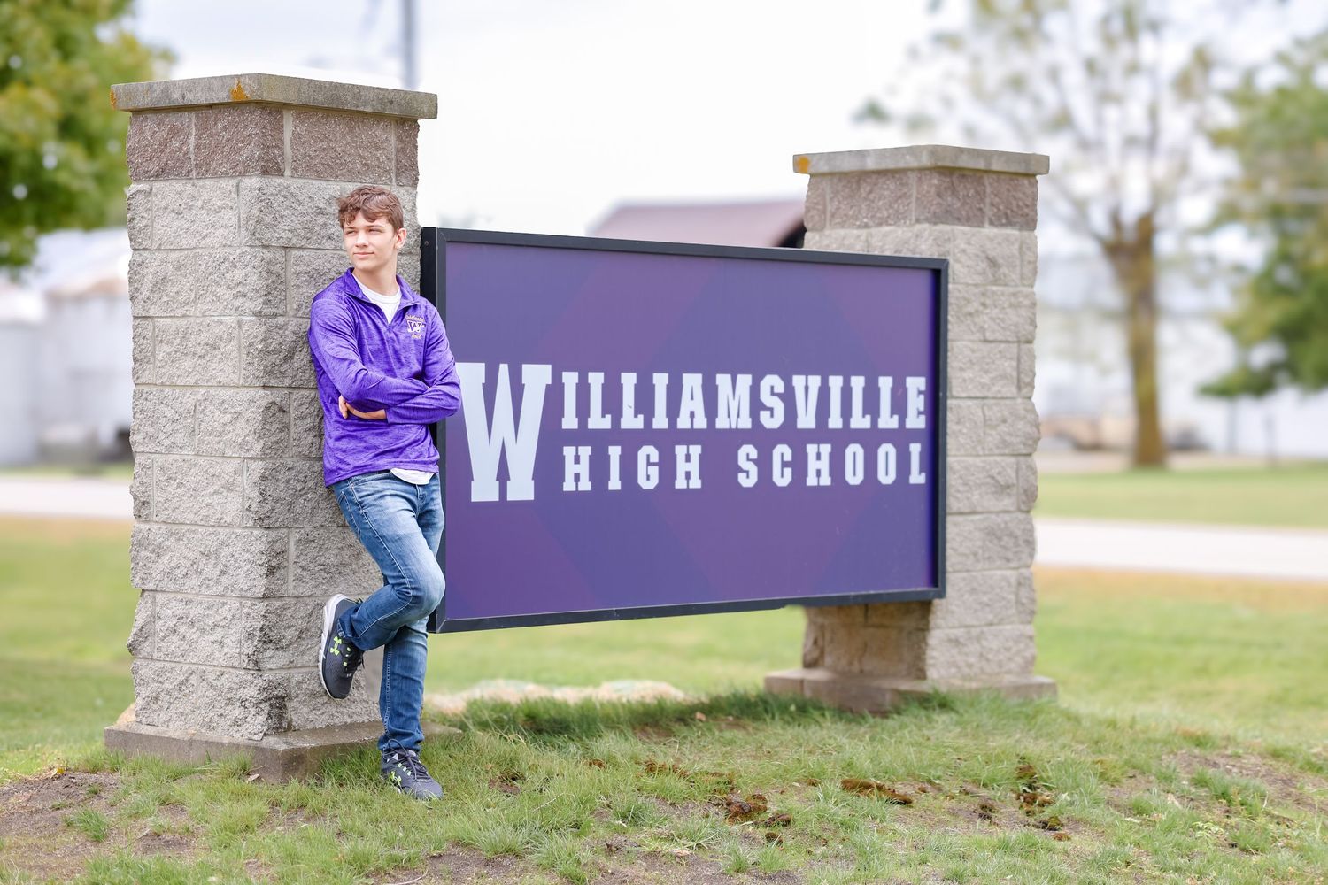 Central Illinois photographer captures a senior in front of their high school sign during a senior session in Williamsville, IL