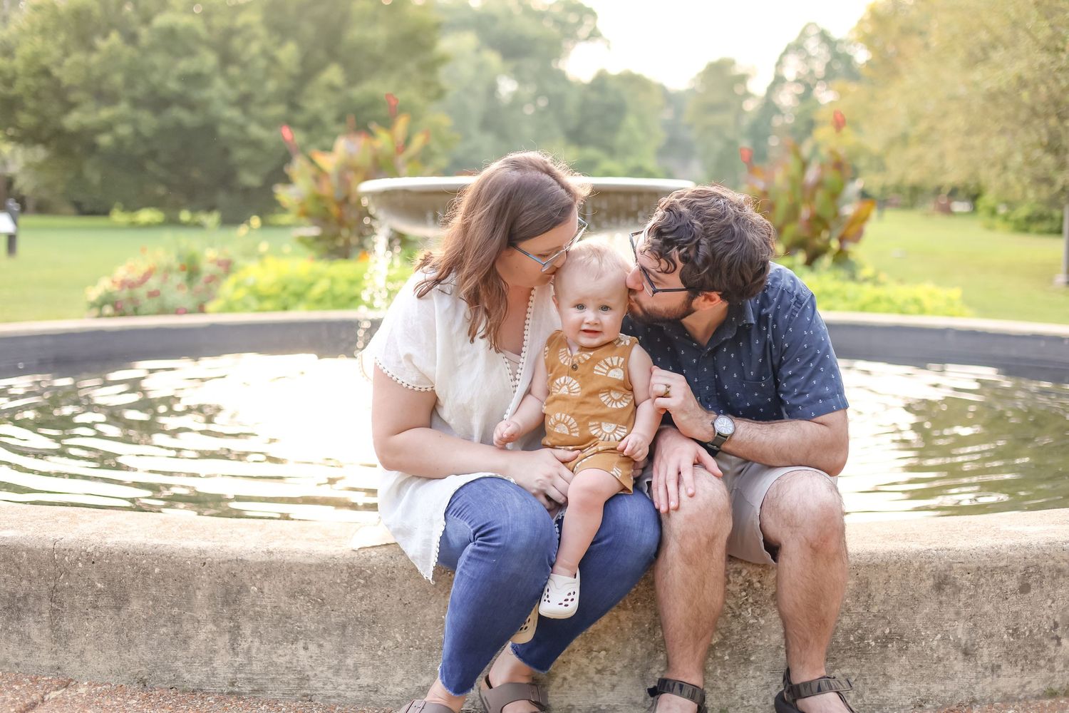 Central Illinois photographer captures a small family together while kissing a baby during a family photo session in Springfield, IL