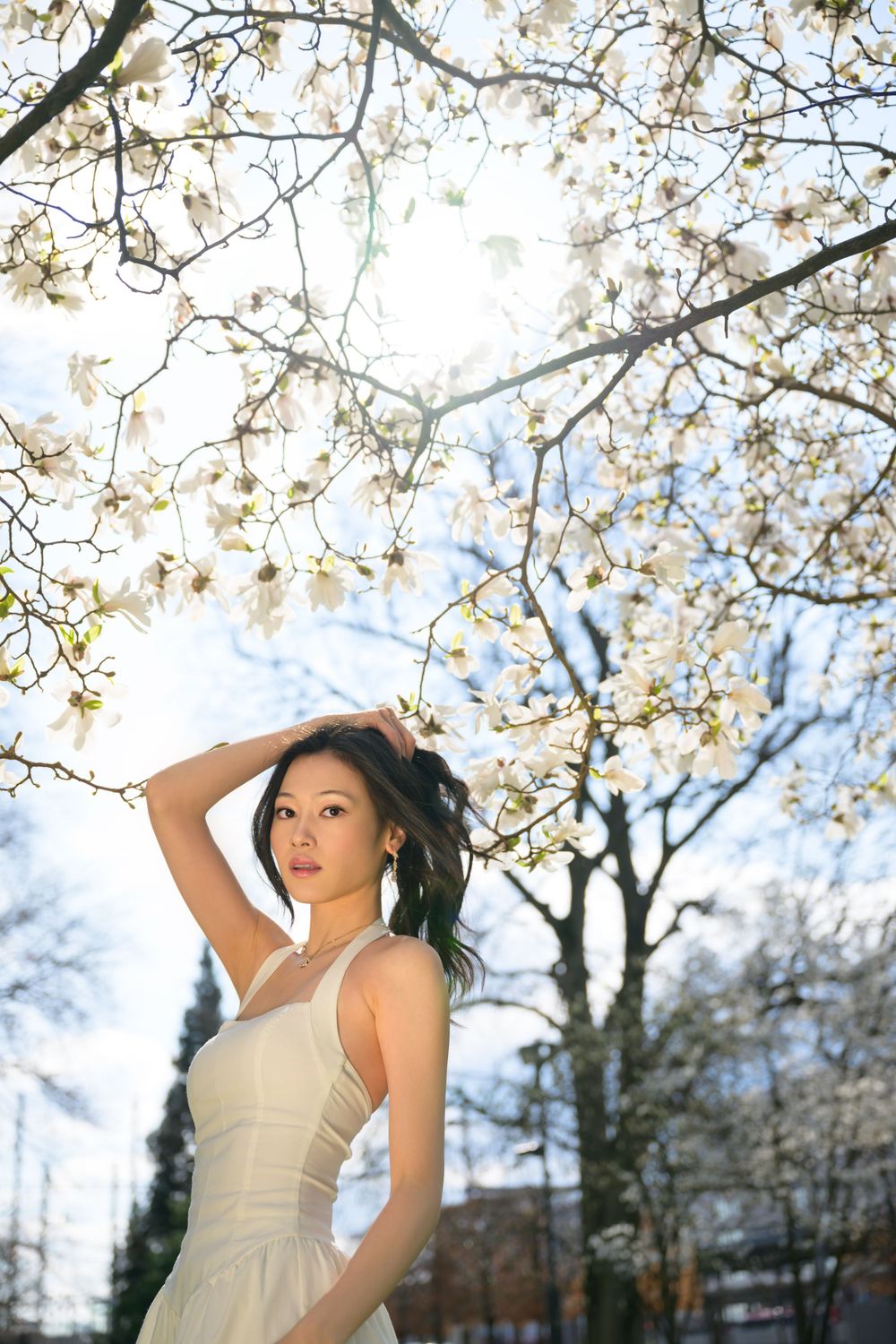 Stylish model posing under blooming trees in Zurich. High quality fashion photo with soft tones and professional lighting. Fotos