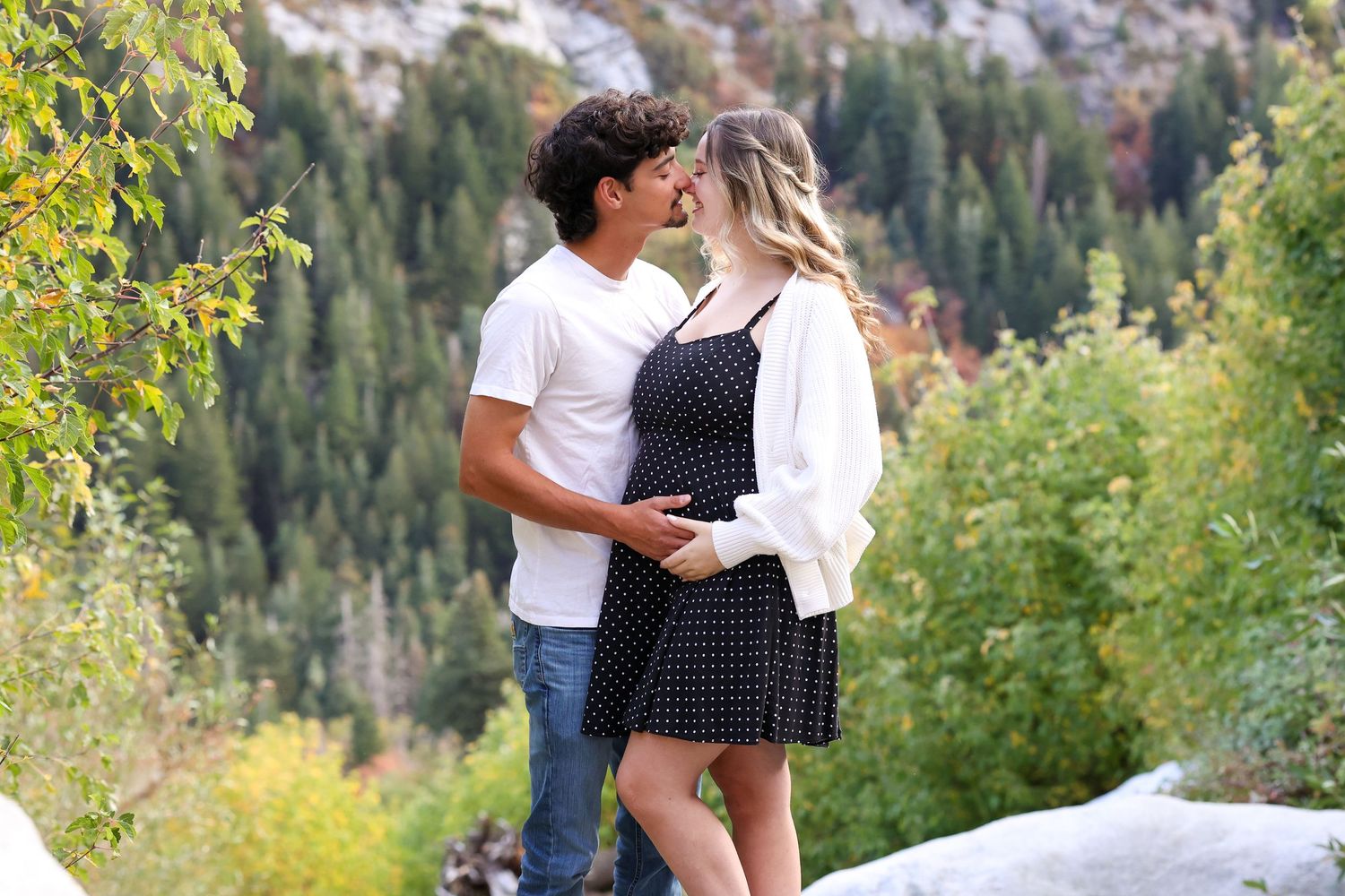 Couple standing near greenery and sunlight