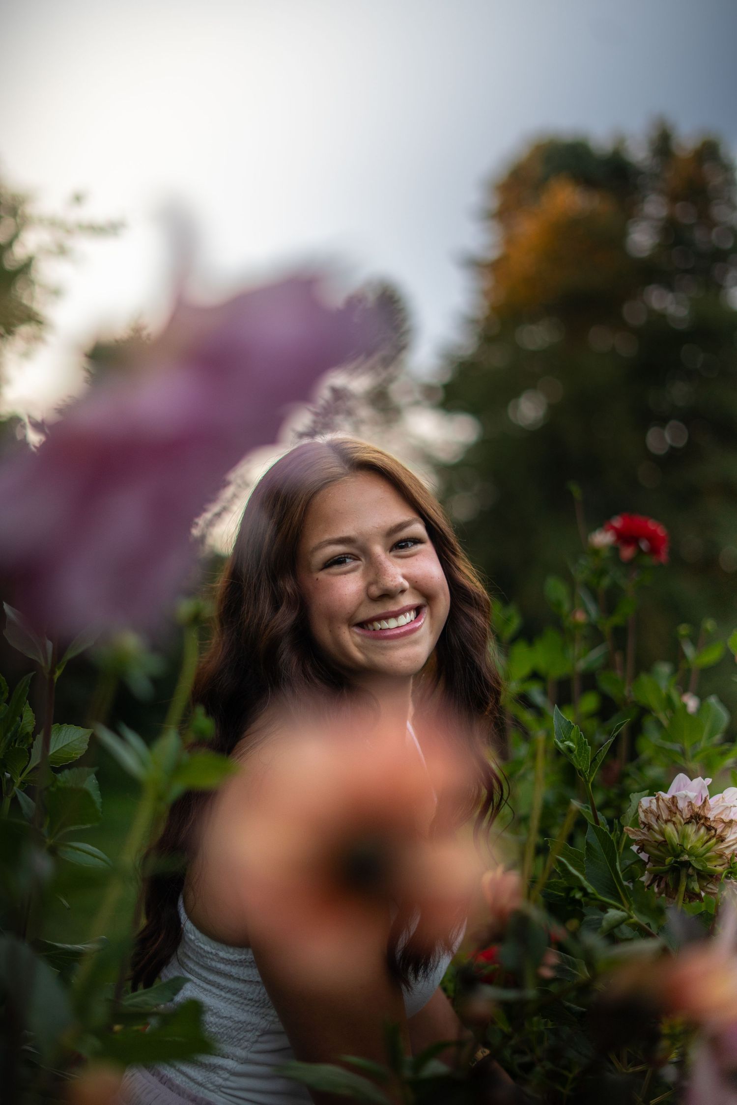 A series of portrait photos in a garden setting with flowers and greenery in late afternoon light.