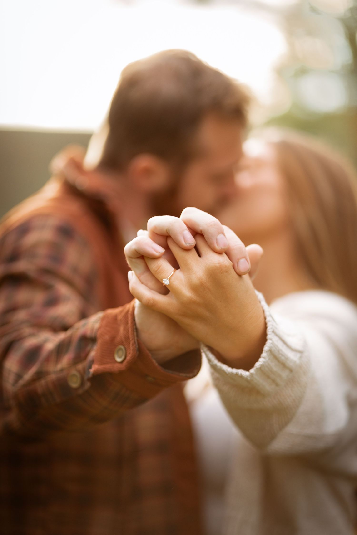 happy couple celebrating just getting engaged. showing her engagement ring by holding both hands up to the camera