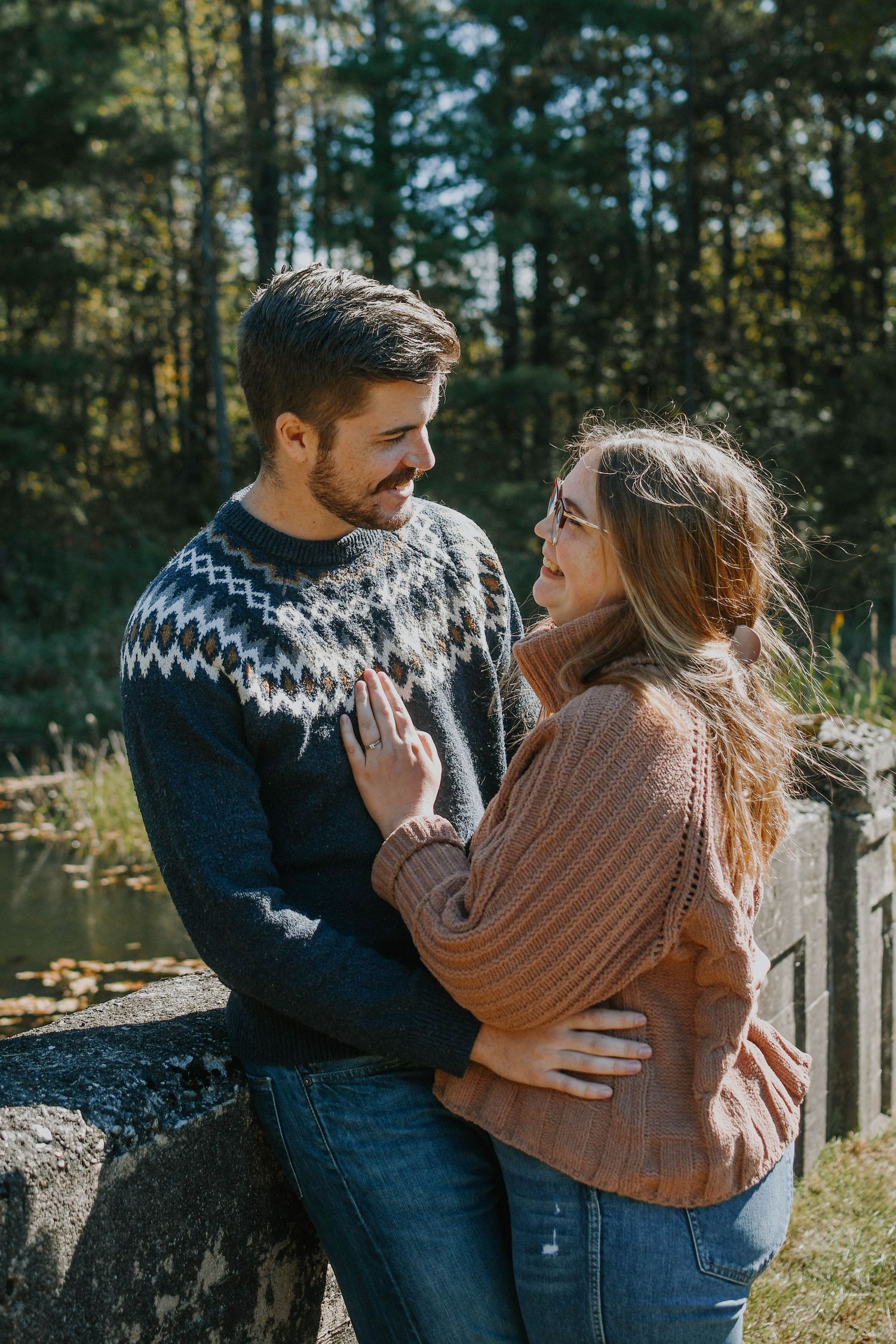 Couple in cozy sweaters sharing intimate moment outdoors.