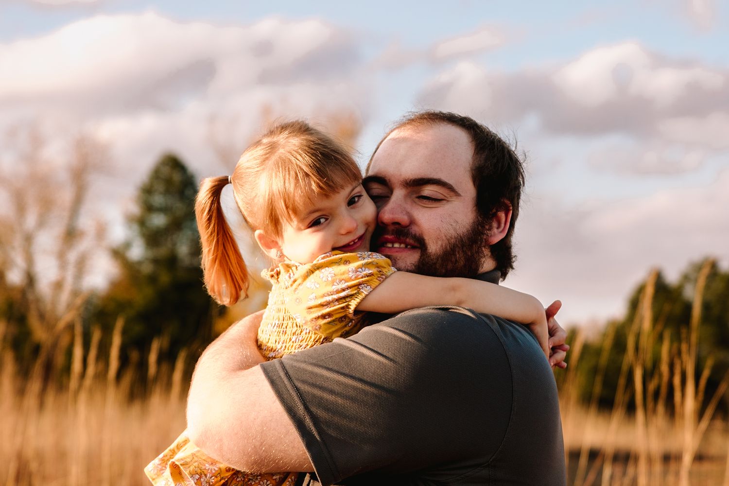 Warm embrace captured during golden hour in field of tall grass.