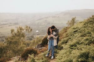 A newly engaged couple embracing one another on a scenic mountain landscape. Captured by Lincolnshire photographers.