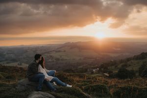 A dramatic mountain landscape at sunset with golden light streaming through clouds over rolling hills. Taken by Lincolnshire photographers.