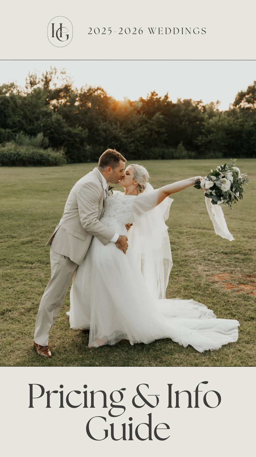 A couple rests romantically on a grassy lawn during sunset with flowing white wedding attire creating an ethereal scene.