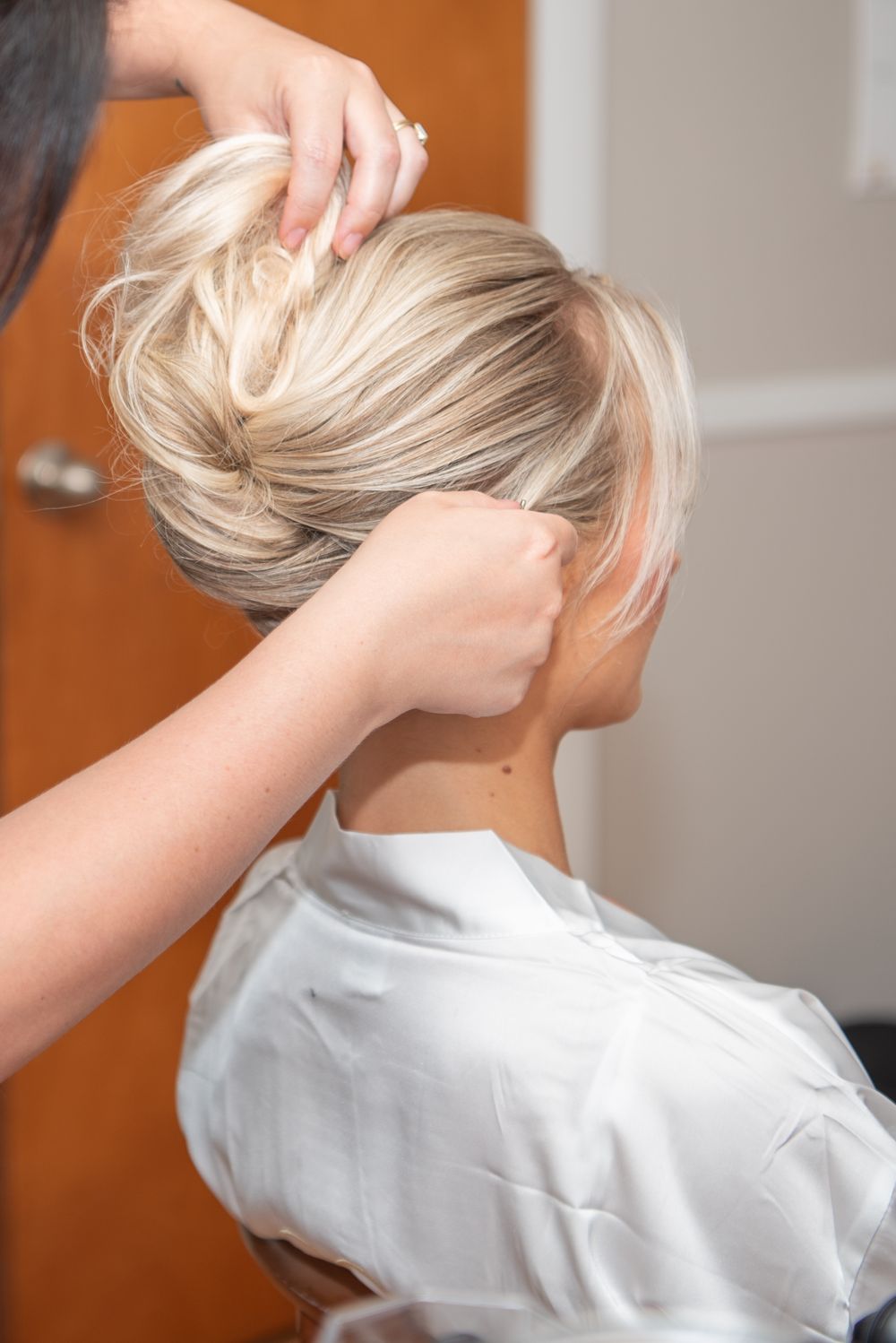 Getting ready scene with hair styling in a white robe.