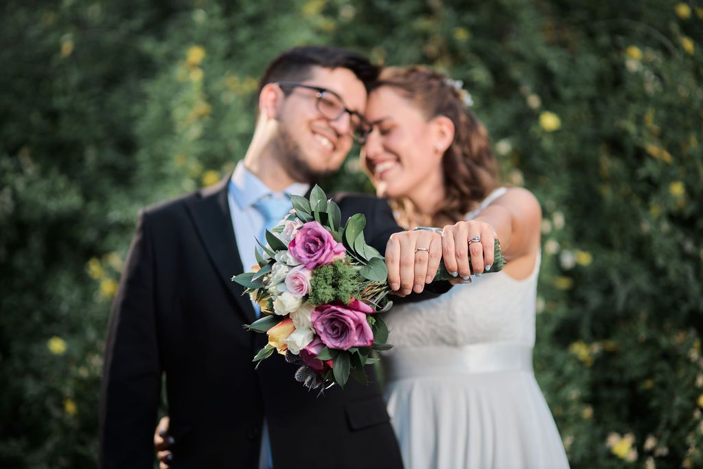 Intimate romantic wedding scene near window showing couple embracing in a rustic cabin setting.