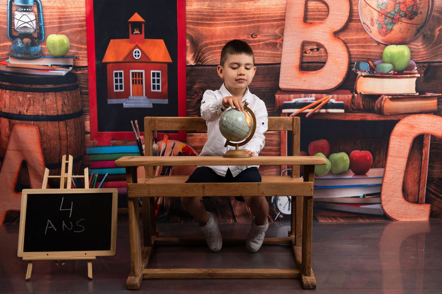 School-themed photo setup with wooden backdrop, chalkboard, and educational props.
