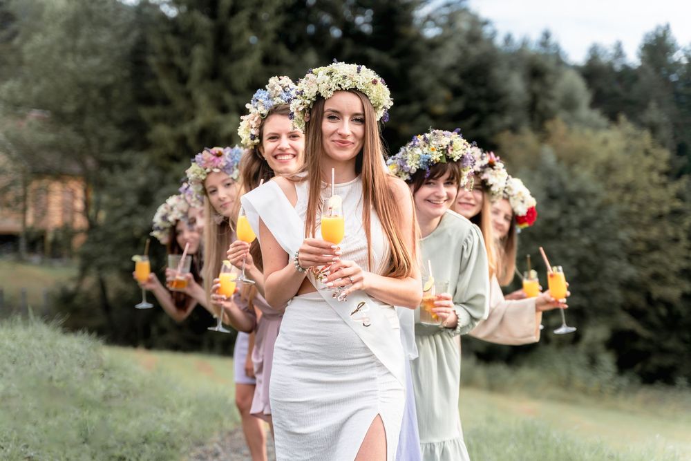 Przyjaciółki bawią się podczas sesji wieczoru panieńskiego w Beskidach, Dobra, pozują z drinkami w ramach sesji w stylu boho.