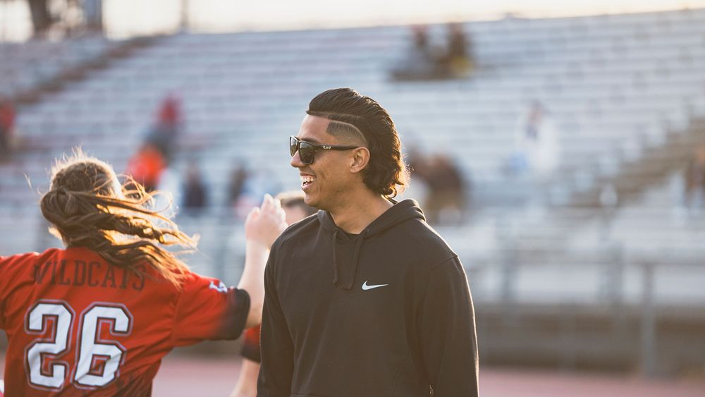 Girls flag football coach looking off left frame
