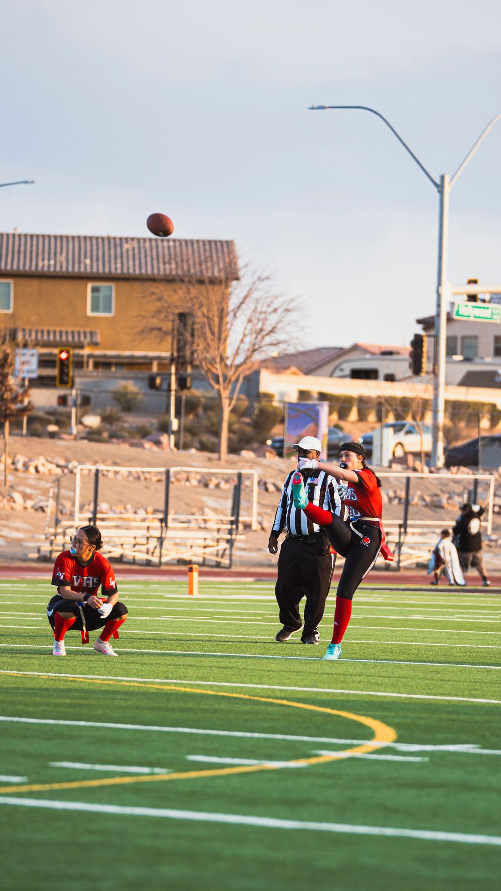 Girls flag football player kicking off the football
