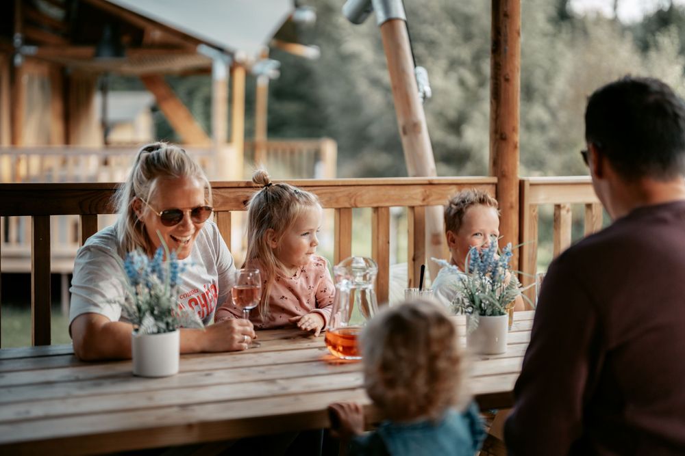 People enjoying drinks and conversation at an outdoor bar counter.