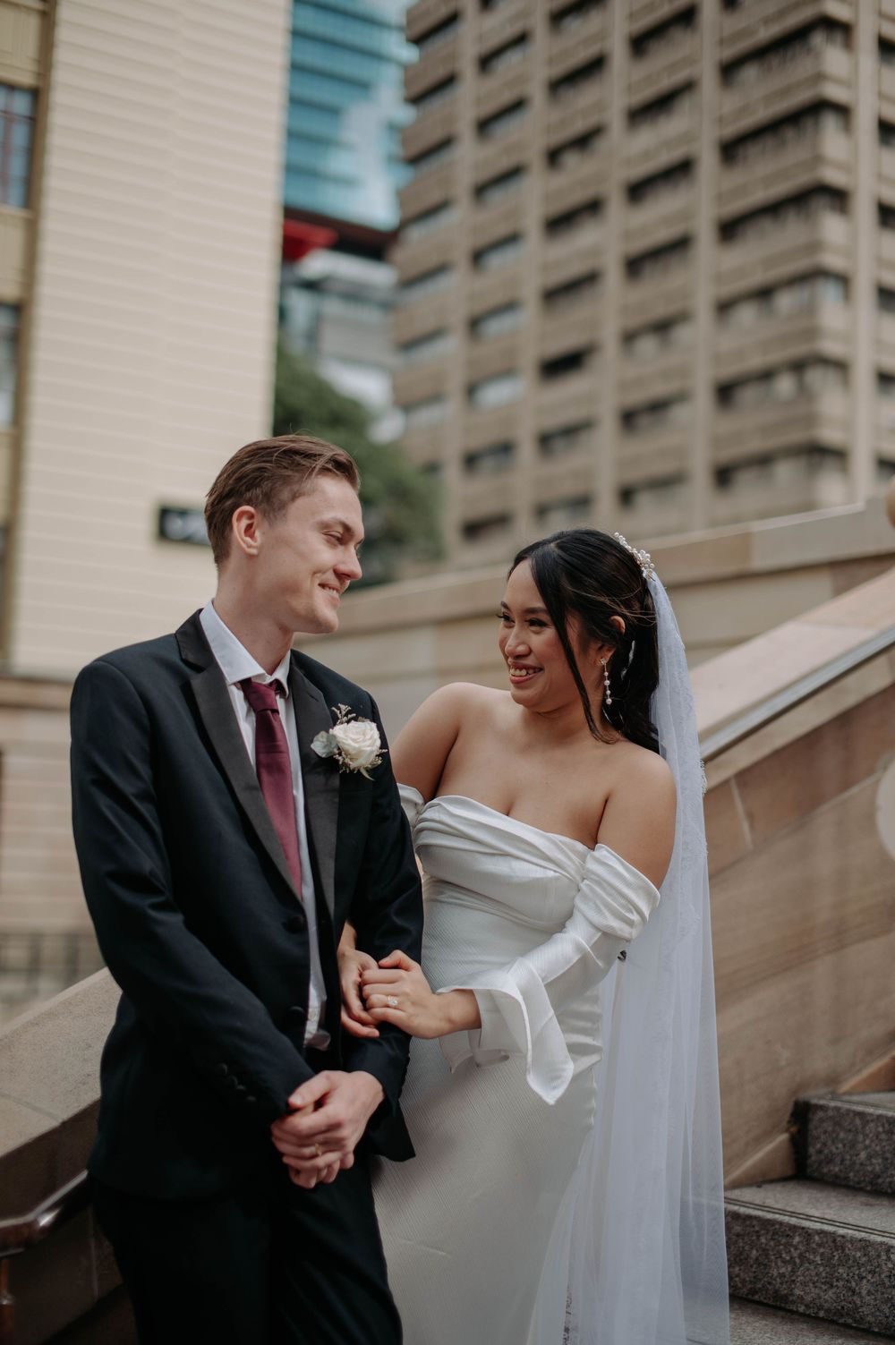 A romantic wedding photo sequence of newlyweds sharing intimate moments on urban stone steps.