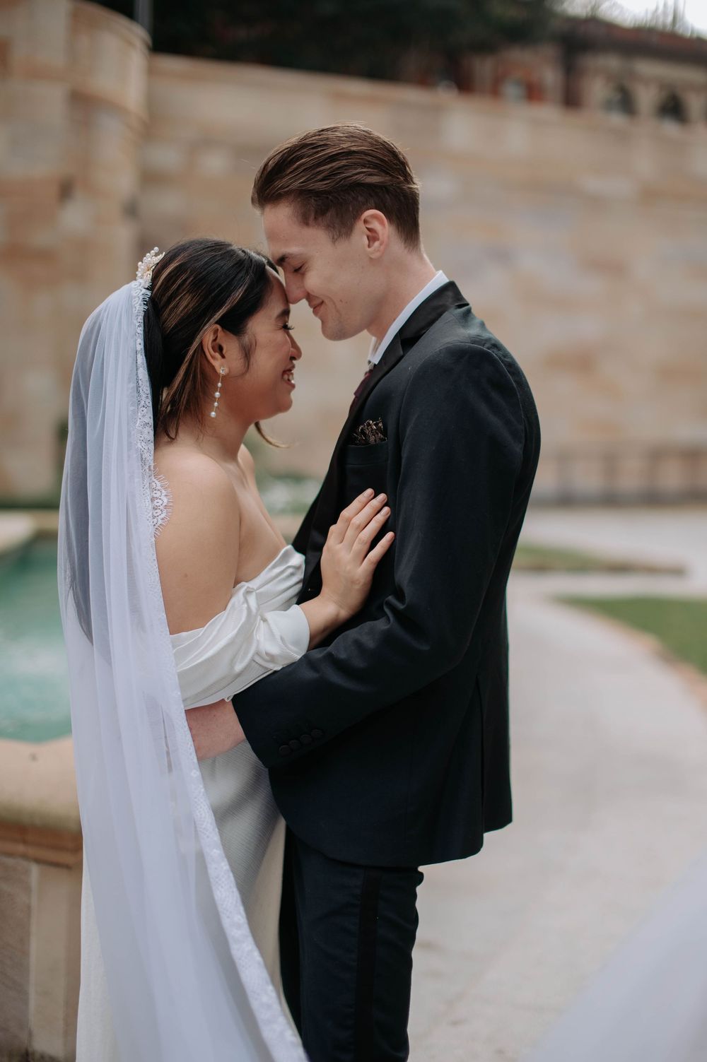 Intimate wedding photos capture tender moments between bride in white and groom in black suit outdoors.