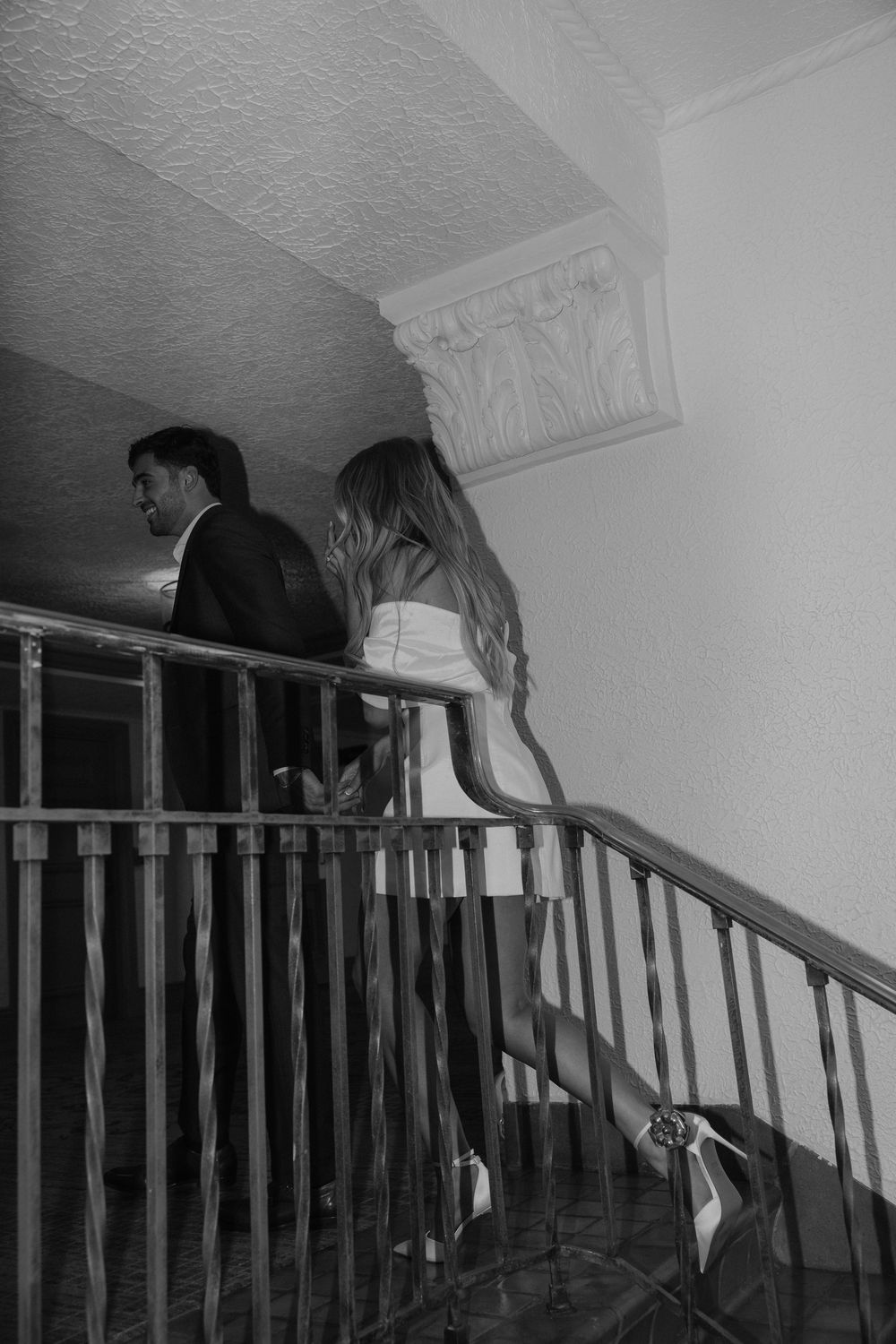 Black and white sequence showing a figure crawling down a staircase in an eerie manner.