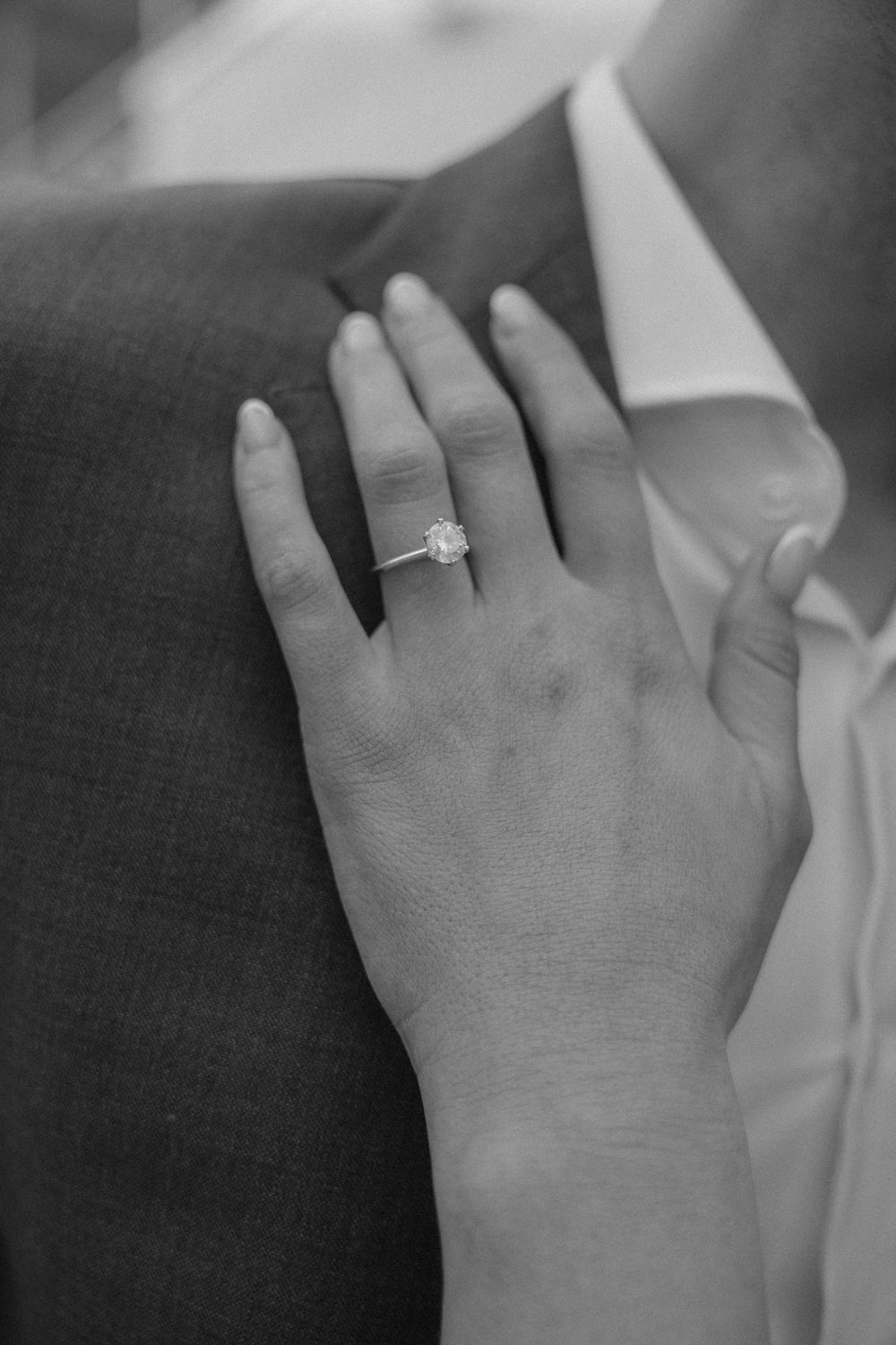 Close-up series of a diamond engagement ring on hand against light fabric background.