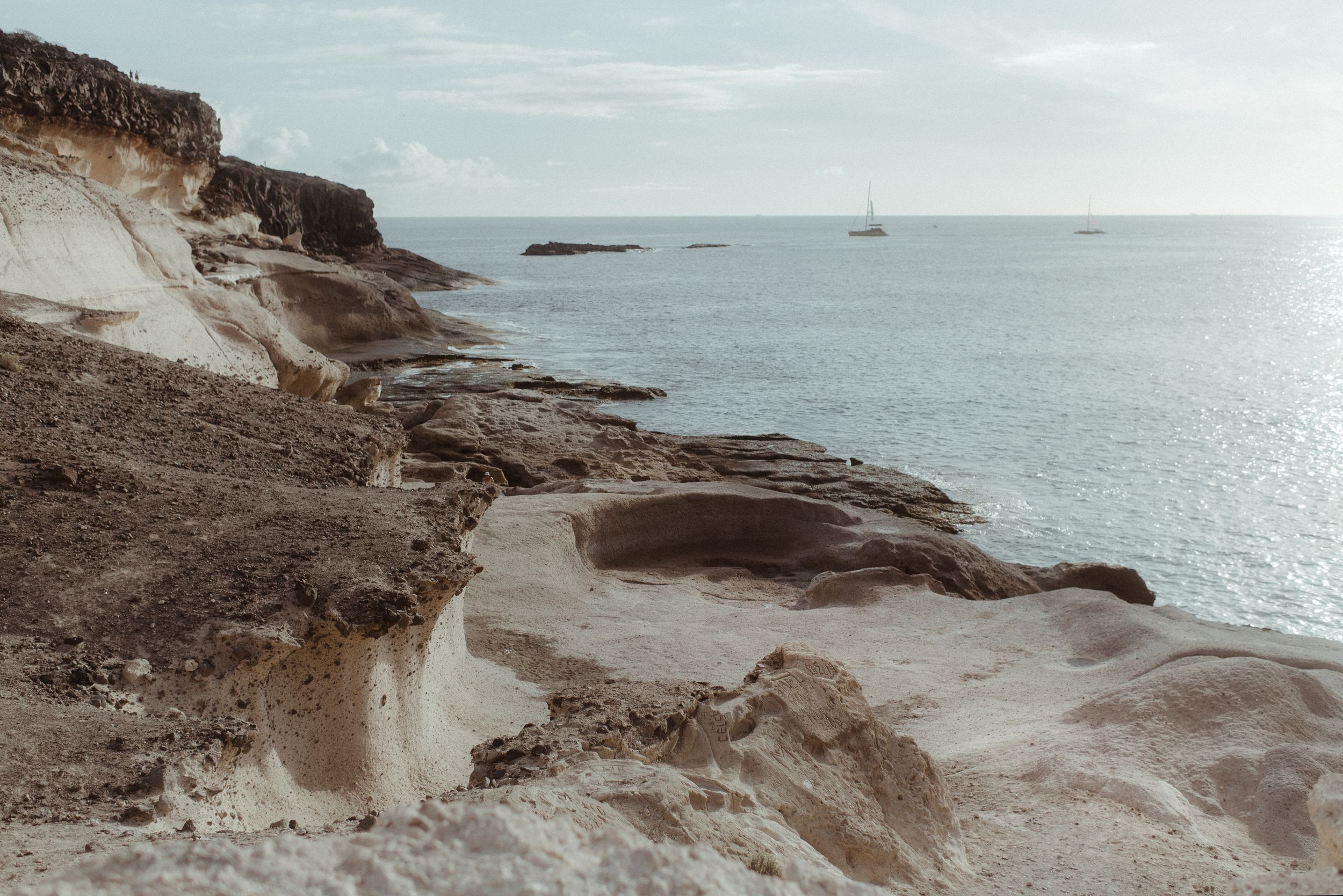 Rugged coastal cliffs and rock formations stretch along a dramatic ocean shoreline at Costa Adeje.