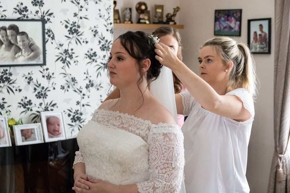 The hairdresser fixing the veil for a bride just before she leaves to get married. Anglesey Wedding Photography
