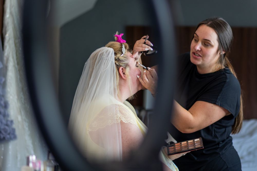 A bride and makeup artist during prep on a wedding morning. North Wales Wedding Photography.
