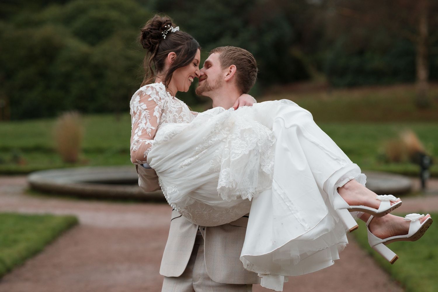 Wortley Hall - Wedding couple posing on orange carpet under stone archway in elegant setting. Sheffield Town Hall