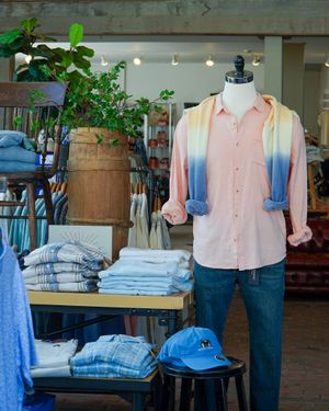 Retail clothing display with pastel shirt and denim in boutique setting.