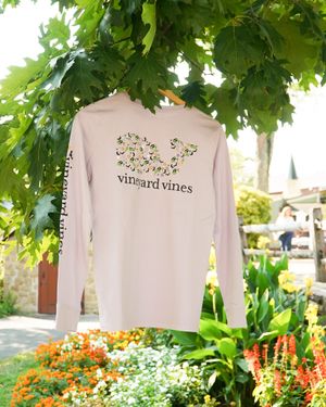 Light pink long sleeve Vineyard Vines shirt with whale design hanging outdoors.