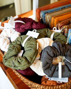Colorful collection of quilted jackets arranged in woven basket display.