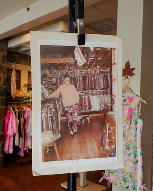 Vintage photograph of clothing store interior displayed on retail rack.