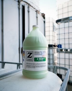 A gallon jug of green Z-Man cleaning solution sitting on a white surface.
