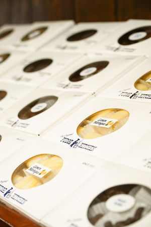 Rows of packaged fudge boxes with circular window displays arranged on wooden surface.