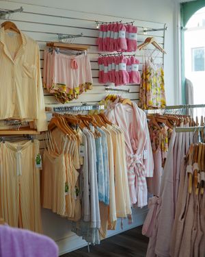 Boutique clothing rack display featuring pastel dresses and blouses in soft spring colors.